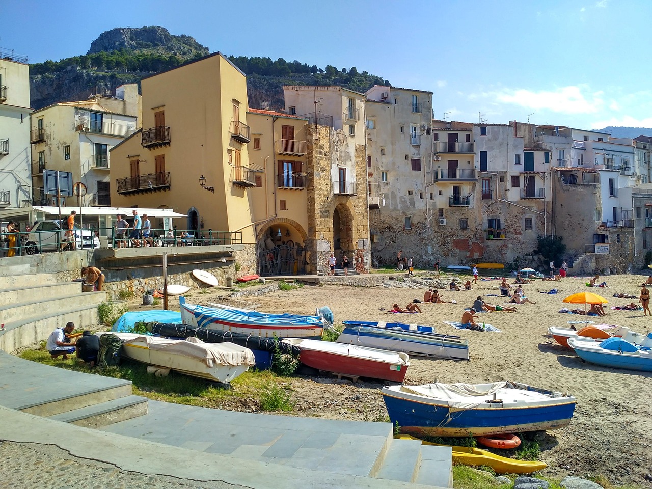 Vista panoramica di Cefalù con la cattedrale e il lungomare affacciato sul mare.