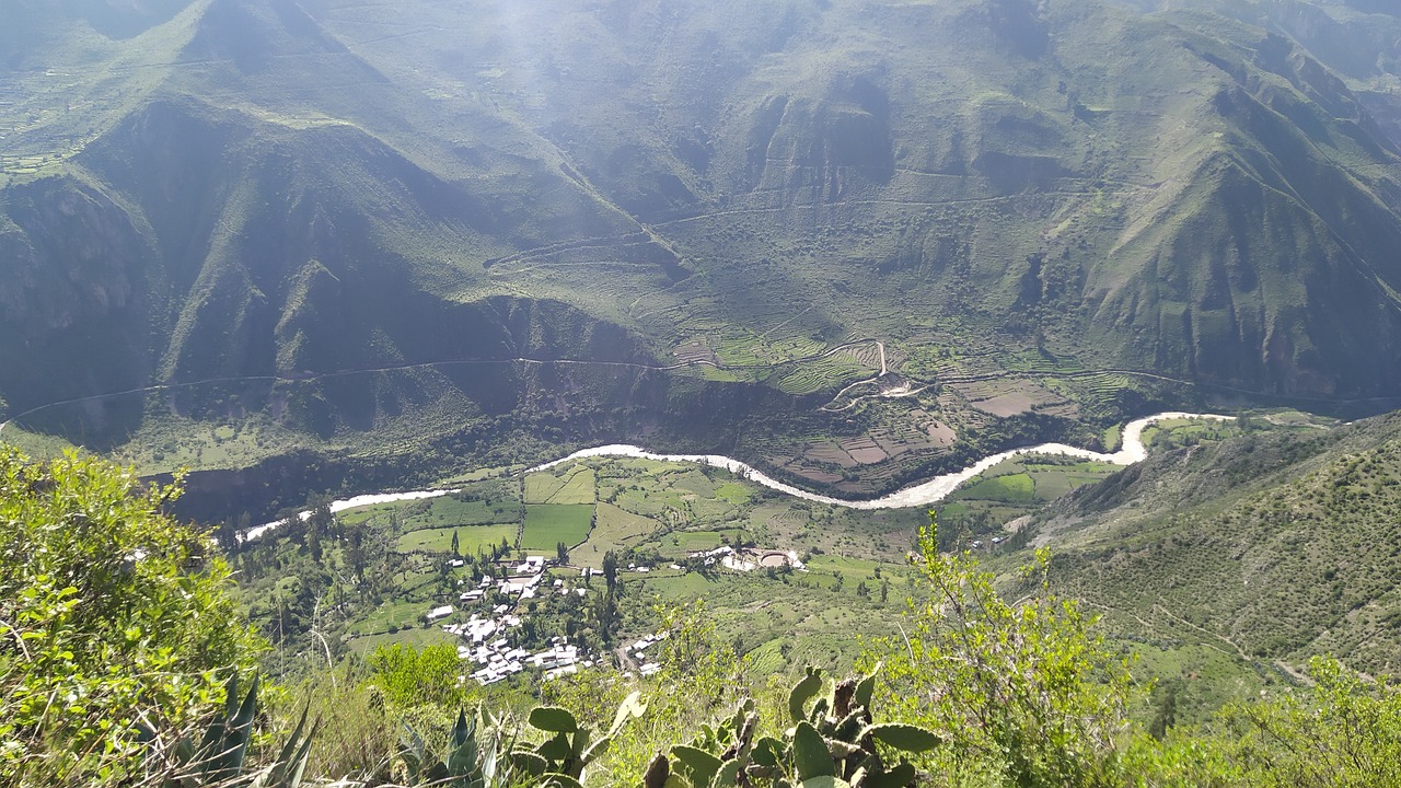 Borgo panoramico con sentieri ripidi, visitatori in cammino con borracce d'acqua.
