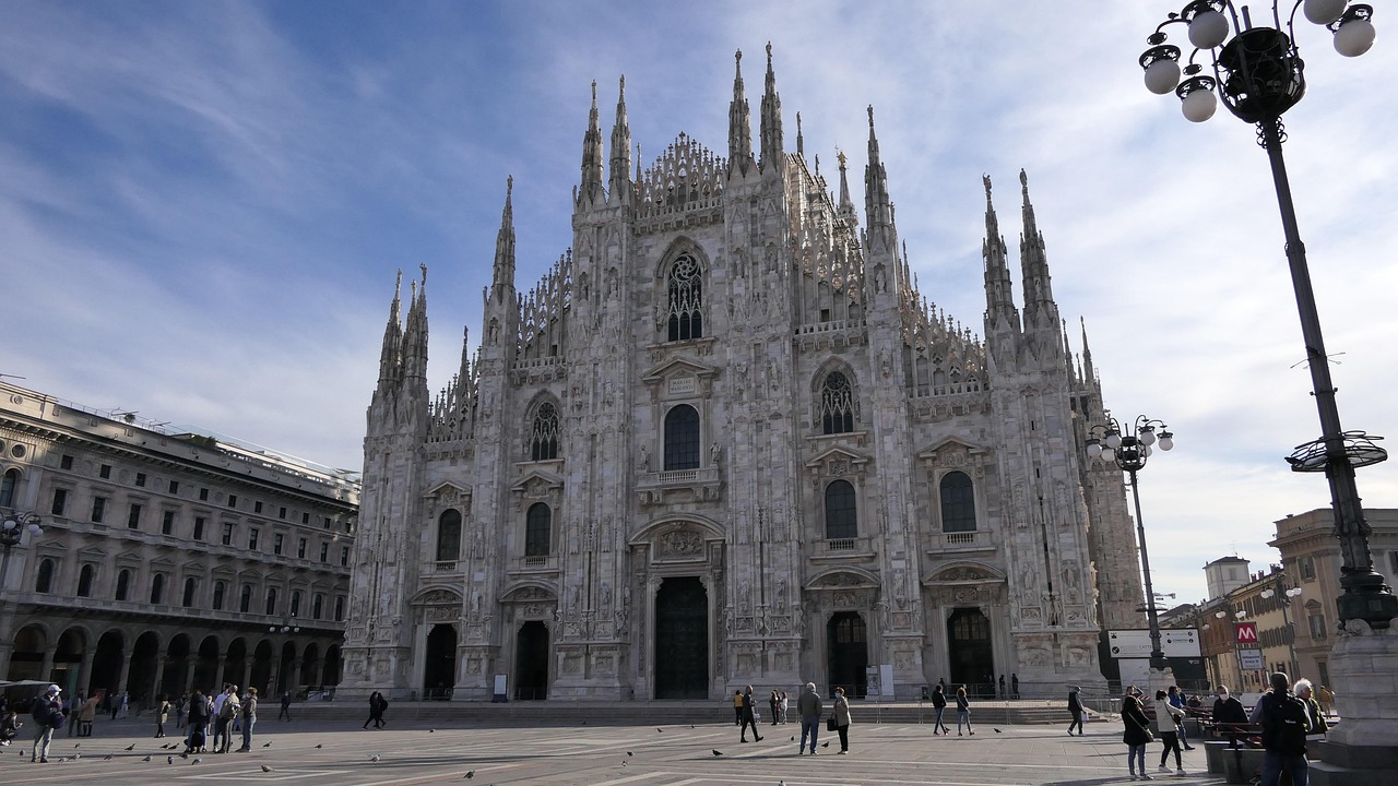 Milano in caos: traffico congestionato e folle di turisti nelle strade.