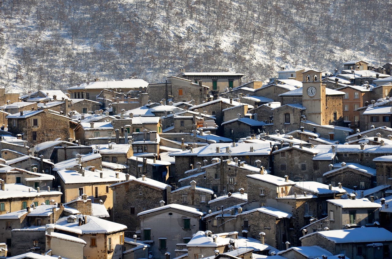 Borgo valdostano panoramico con case in pietra e montagne sullo sfondo, simbolo di attrazione turistica.