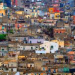 Borgo italiano pittoresco con case colorate, strade acciottolate e paesaggio incantevole.