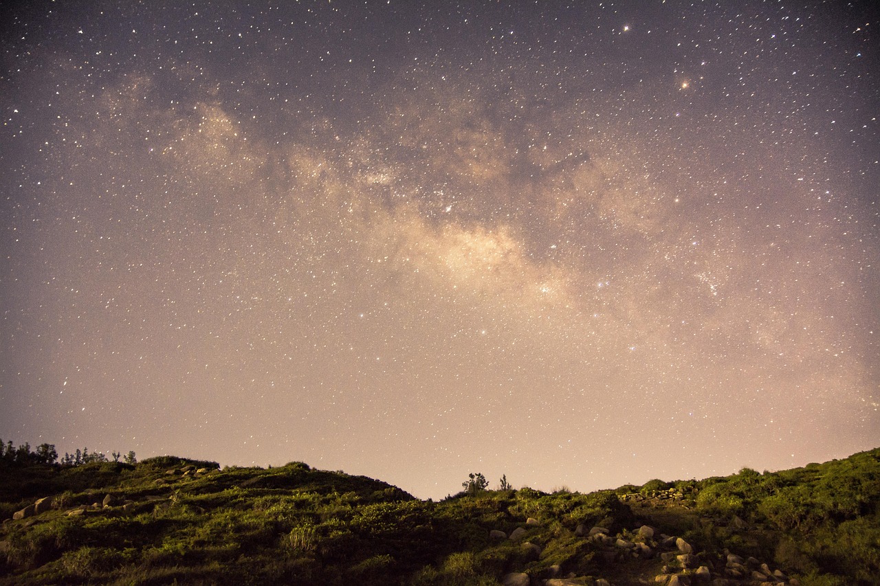 Vista notturna di Pantelleria con stelle brillanti nel cielo e silhouette di paesaggi naturali.