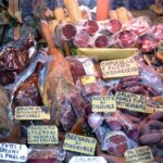 Mercato di San Lorenzo a Roma con bancarelle di prodotti locali freschi e colorati.