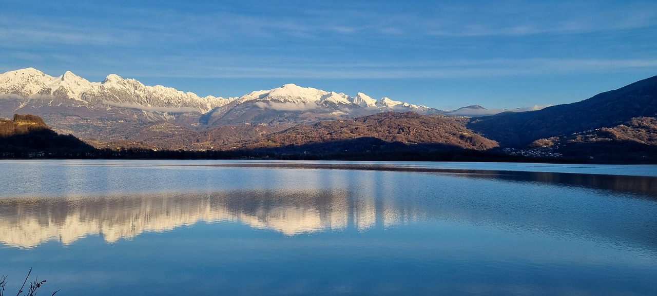 Vista panoramica del lago incantevole in Friuli, circondato da natura e montagne.