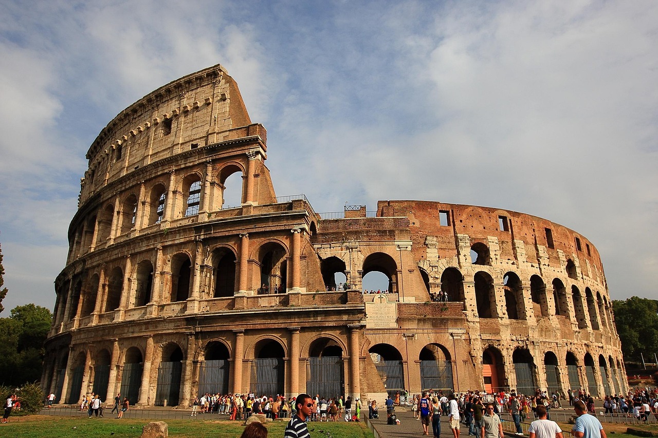 Turista deluso davanti al Colosseo in un giorno piovoso a Roma, evidenziando il clima sfavorevole.