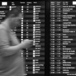 Persona che consulta un'app per voli ritardati con un'espressione pensierosa.
