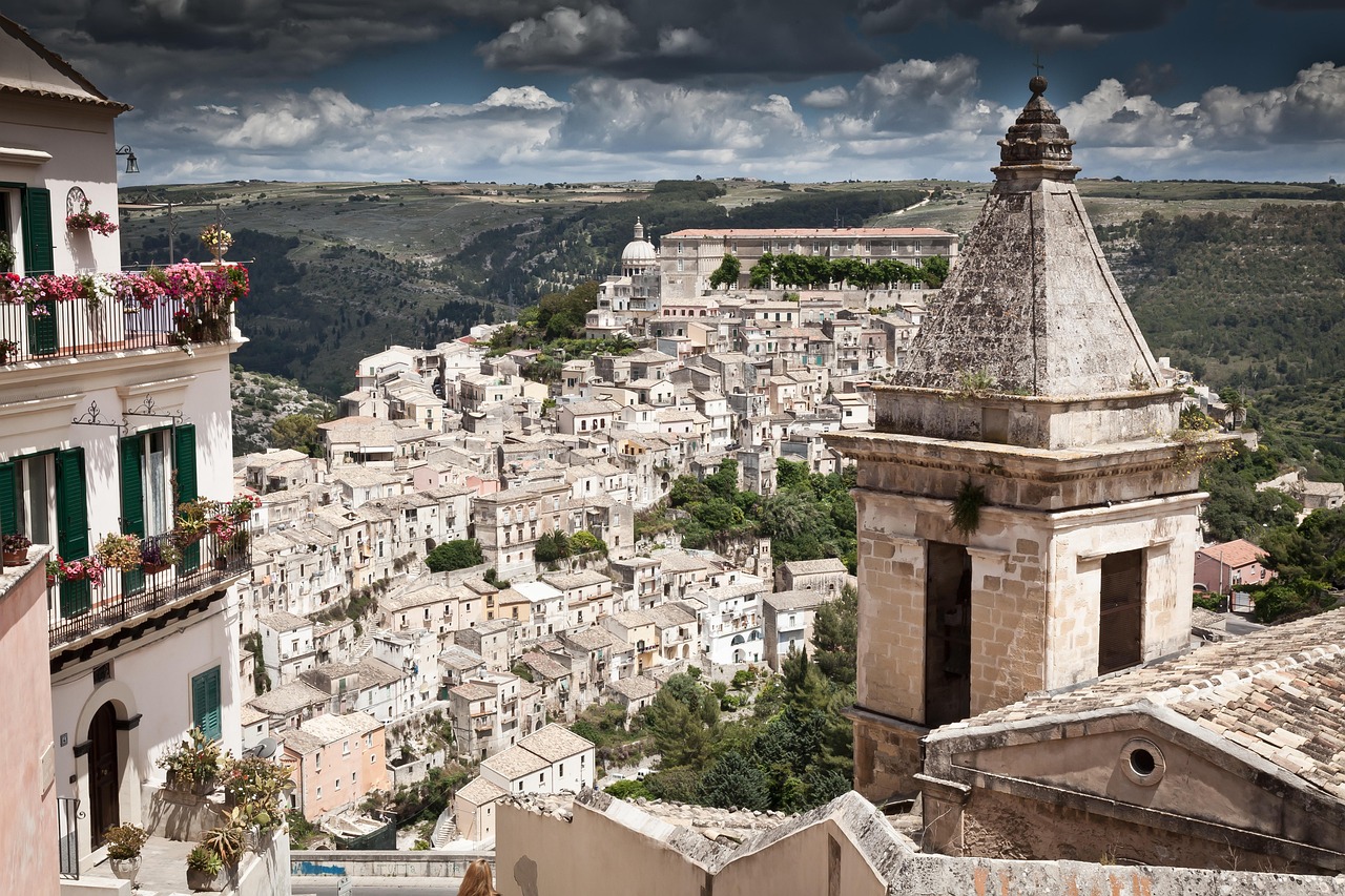 Panorama di Modica con cioccolato artigianale in primo piano, simbolo della tradizione siciliana.