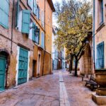 Panorama di una caratteristica cittadina francese con strade acciottolate e case colorate.