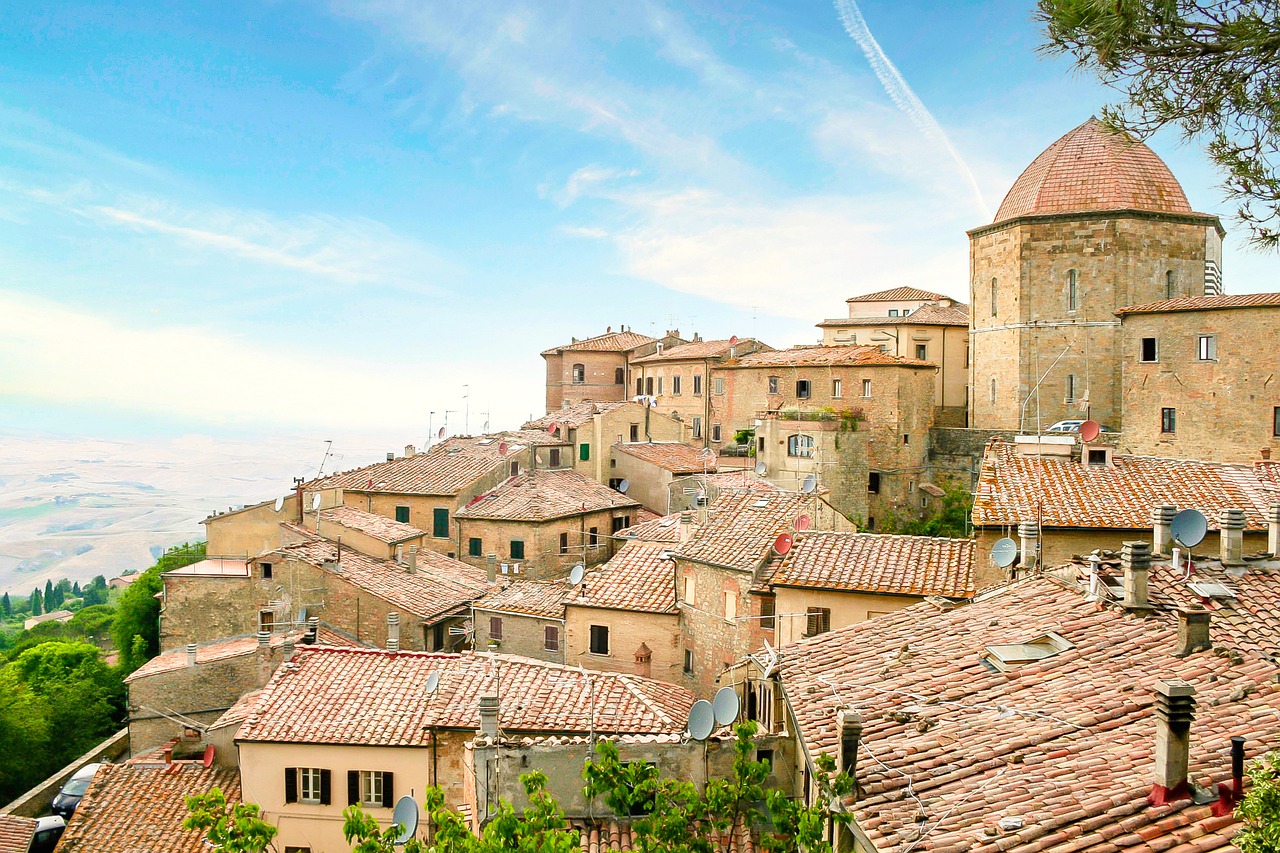 Vista panoramica del borgo marchigiano con piatti tipici e mare sullo sfondo.