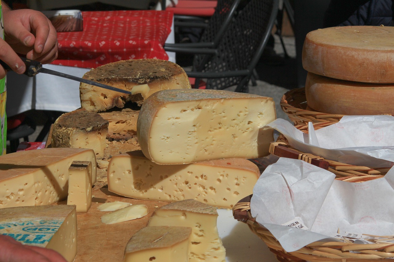 Paesaggio abruzzese con formaggi tipici e stand gastronomici durante un festival locale.