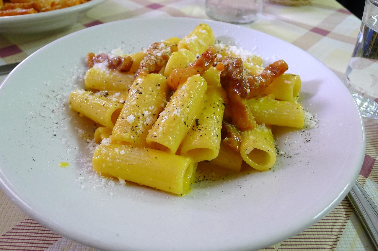 Carbonara perfetta servita in un ristorante romano, con guanciale croccante e pecorino grattugiato.