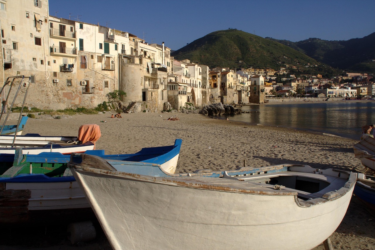 Porto calabrese con spiagge di sabbia bianca e ristoranti sul mare al tramonto.
