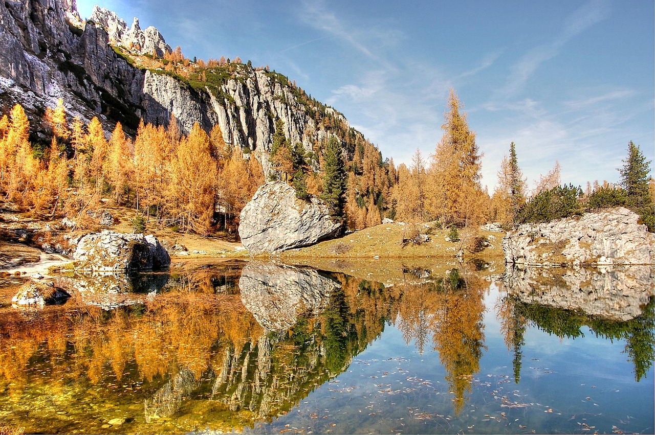 Vista panoramica del Lago di Braies circondato da alberi dai colori autunnali.