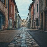 Borgo con la via più stretta d'Europa, mostrando un passante che cammina di profilo tra le pareti.