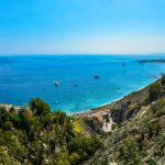 Spiaggia segreta in Calabria con mare cristallino e sabbia bianca, vista panoramica incantevole.