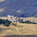 Borgo pittoresco con case antiche, deserto, simbolo di tranquillità e curiosità per i viaggiatori.