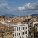 Terrazza panoramica a Napoli con vista sul Vesuvio e cocktail serviti al tramonto.