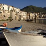 Vista panoramica del tranquillo borgo marittimo calabrese con mare cristallino e case colorate.