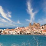 Paesaggio incantevole di un paese italiano sconosciuto, con colline verdi e antichi edifici storici.