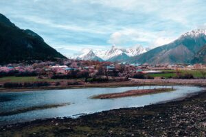 Panorama di un borgo di montagna immerso nella natura, con case tradizionali e montagne sullo sfondo.