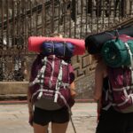 Escursionista sul Cammino di Santiago, circondato da paesaggi naturali e sentieri storici.