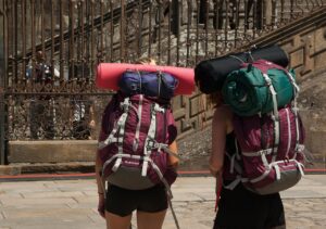 Escursionista sul Cammino di Santiago, circondato da paesaggi naturali e sentieri storici.