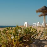 Spiaggia nascosta in Portogallo, con sabbia dorata e acque cristalline circondate da scogliere.