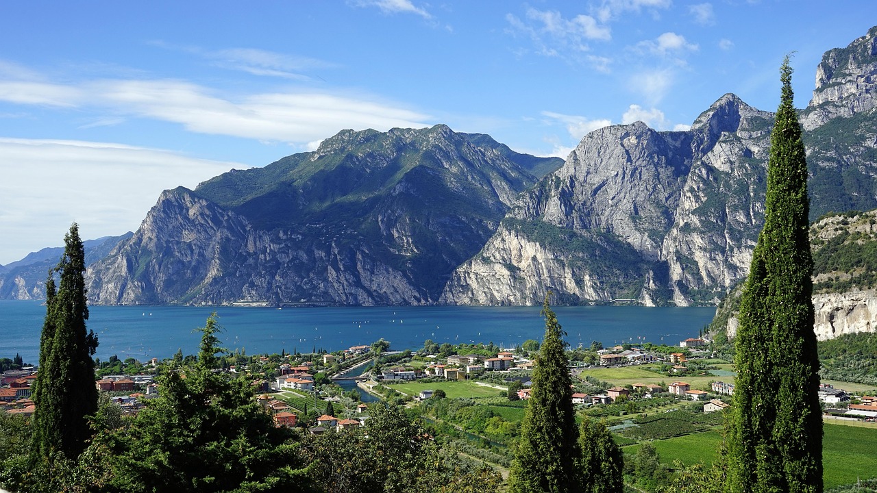 Lago italiano dalle acque blu, circondato da monti, simile a un fiordo norvegese.