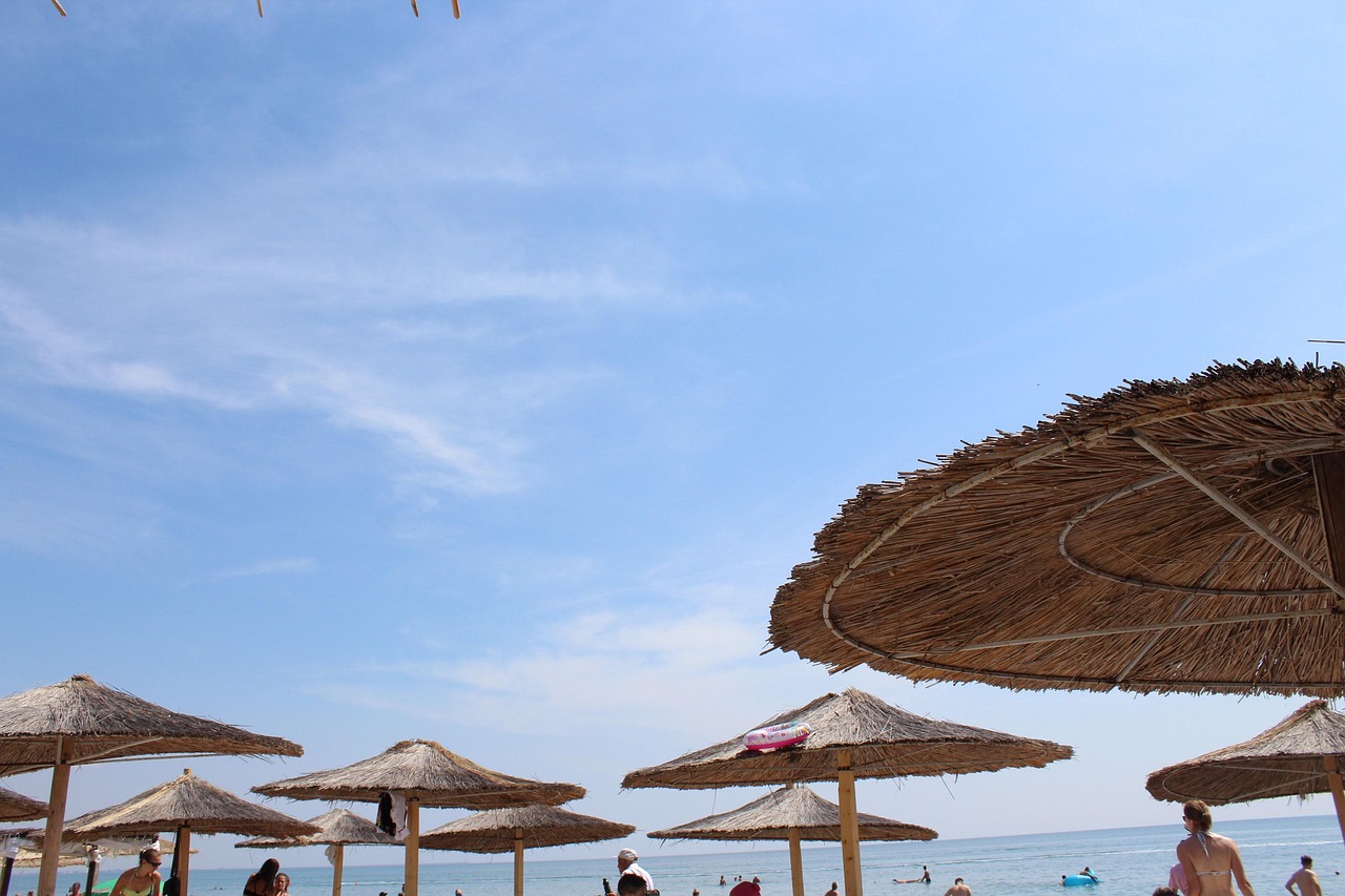 Panorama costiero dell'Albania con turisti, simbolo della crescita dei prezzi nel 2026.