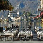 Ristorante sul lago di Iseo con vista sul tramonto e piatti di pesce fresco serviti.