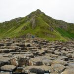 Panorama mozzafiato delle scogliere di Moher in Irlanda, con cielo blu e onde che si infrangono.