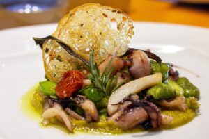 Piatti tipici toscani serviti in una trattoria della Val d'Orcia, circondata da paesaggi suggestivi.