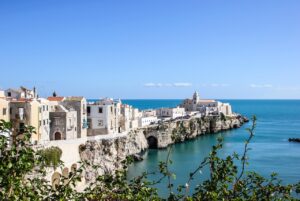 Spiaggia di Vieste con mare cristallino e scogliere bianche al tramonto, simbolo della bellezza italiana.
