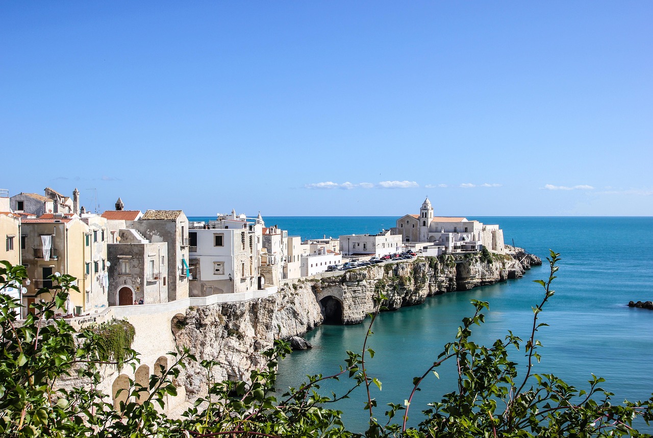 Spiaggia di Vieste con mare cristallino e scogliere bianche al tramonto, simbolo della bellezza italiana.
