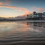 Paesaggio invernale di un incantevole paese costiero con mare azzurro e case decorate.